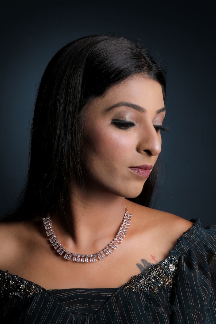 Studio portrait of a woman wearing a sparkling diamond necklace showcasing elegance.